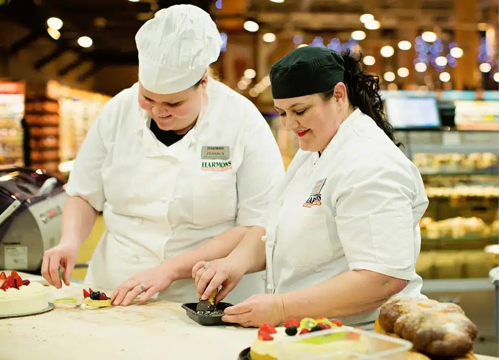 Two Harmons pastry chefs decorating desserts with fresh fruit