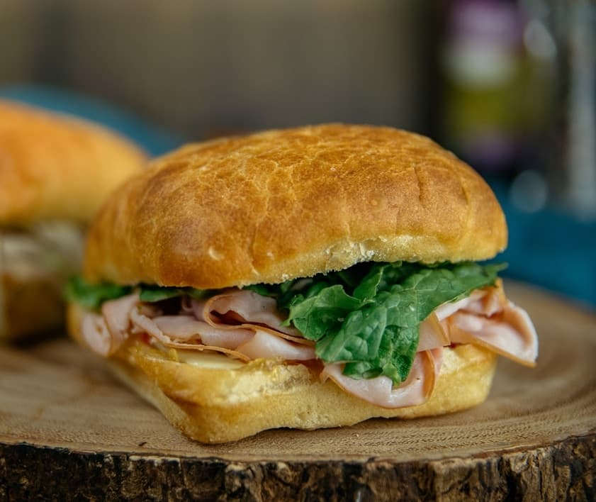 Ham and cheddar sandwich with lettuce on a toasted bun