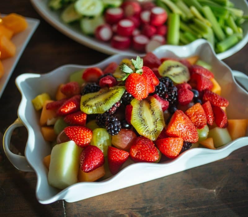 Platter of cut fruit and fresh berries