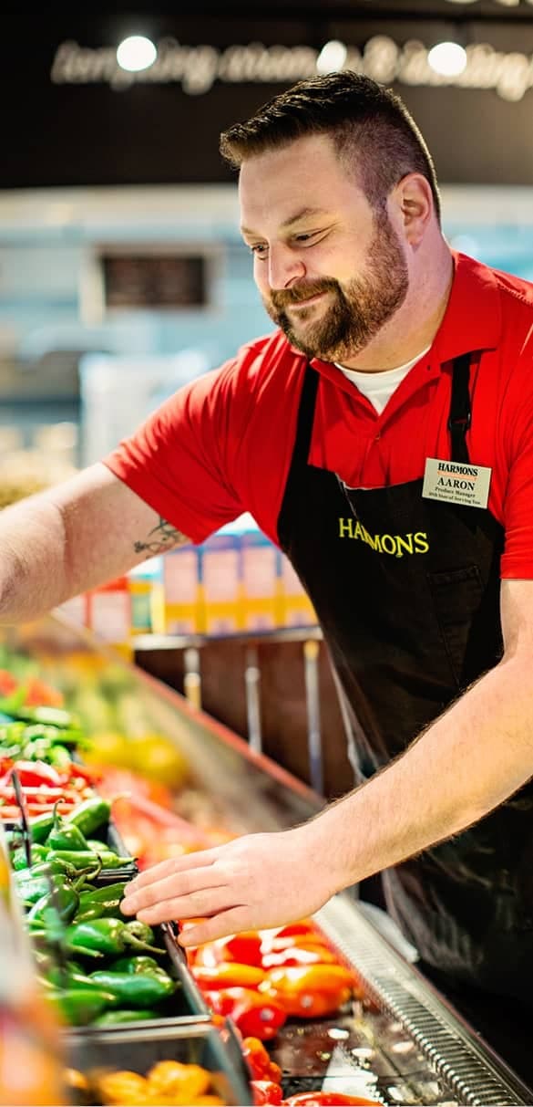 Harmons produce associate at the produce display